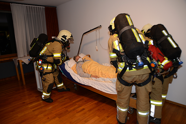 Mithilfe des Evakuierungstuches retten drei Mitglieder der Feuerwehr Nofels beim Probealarm eine betagte Personen.