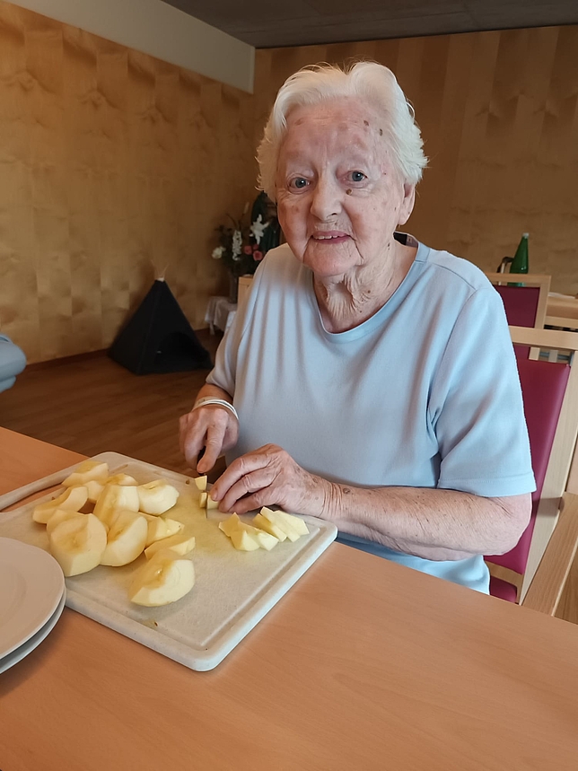 ältere Frau schneidet Äpfel
